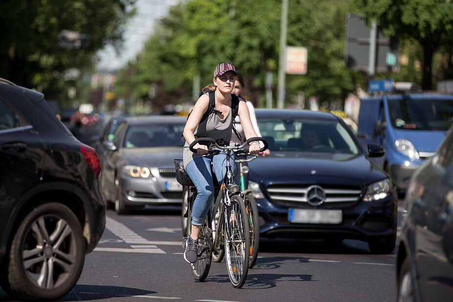 Radfahrerin in dichtem Verkehr Radfahren in der Stadt: Dichter Verkehr